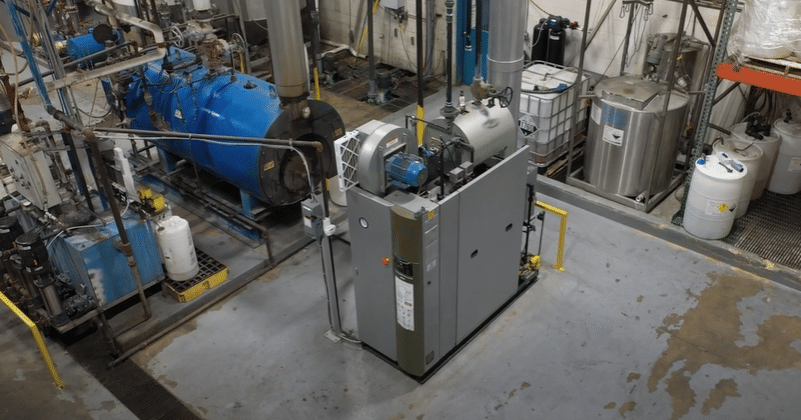 An aerial image of a Miura LX boiler installed in a boiler room, surrounded by additional boiler room equipment.